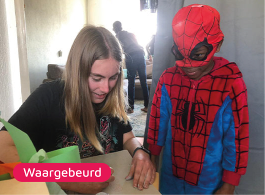 Bliep vrijwilliger tekent spiderman samen met een kind in spiderman pak